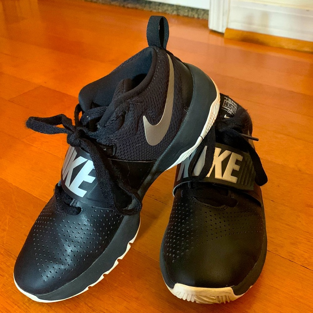 A pair of mens Nike shoes, size 6 in mens. They are black with a little silver.